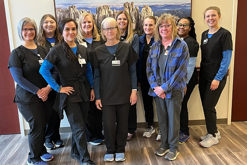 Healthcare staff team posing together inside a medical clinic.