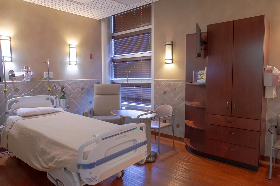 Patient recovery room with hospital bed and medical equipment.