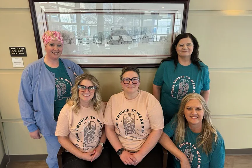 Healthcare professionals posing together in a clinic lobby.